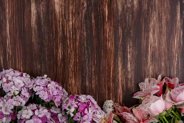 top-view-light-pink-flowers-with-lilies-roses-wooden-surface_141793-17767.jpeg